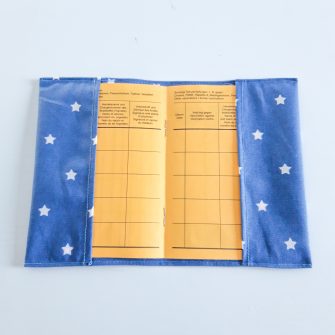 Impfausweishülle für Internationales Impfbuch der WHO in geöffnetem Zustand aus abwaschbarem Stoff in Jeansblau mit weißen Sternen