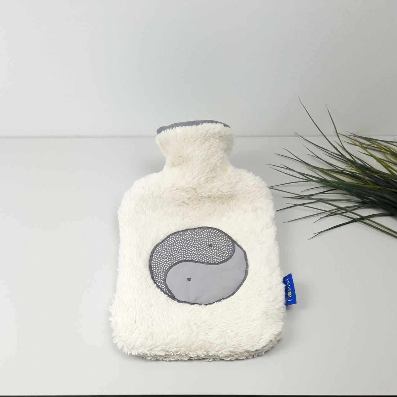 Flosinn Wärmflasche oder Bettflasche mit Bezug aus Bio Teddyplüsch mit einer Yin Yang Applikation in Grau