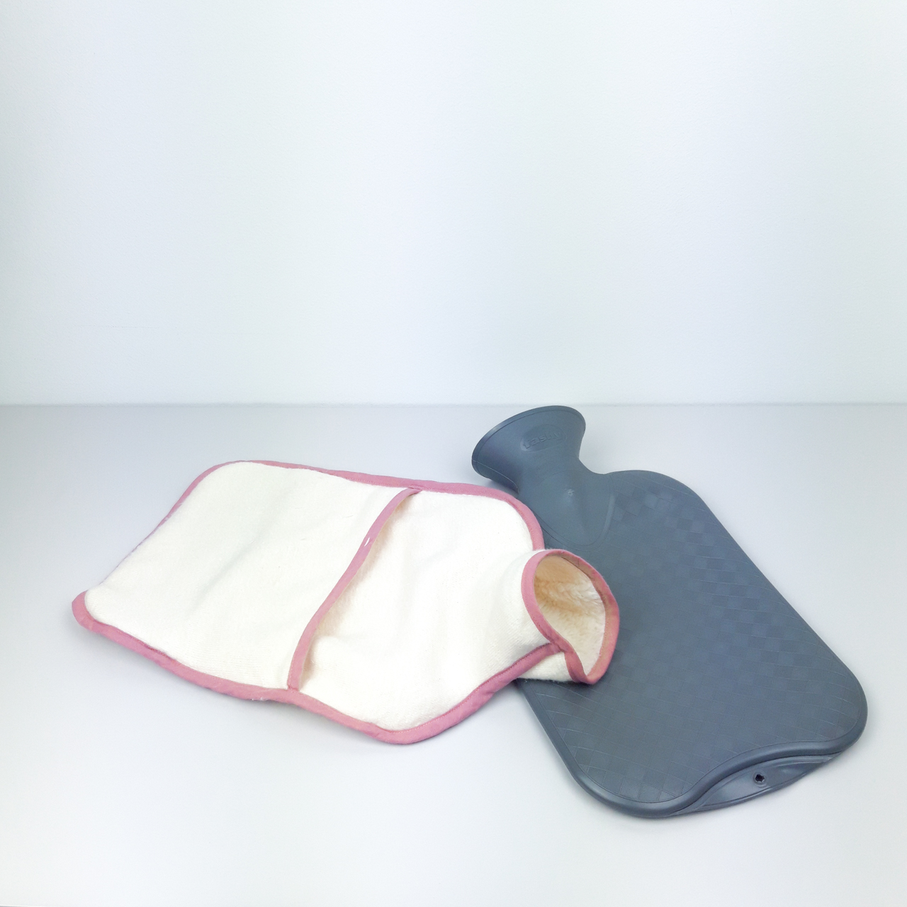 Flosinn Wärmflasche oder Bettflasche mit Bezug aus Bio Teddyplüsch mit einer Yin Yang Applikation in Rosé Innen